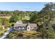 An aerial perspective captures a modern home adjacent to the golf course, with a long drive and mature trees at 1183 Farm Quarter Rd, Mount Pleasant, SC 29464