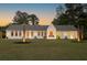 A single-story home with black trimmed windows, palm trees, and an expansive green lawn at 1183 Farm Quarter Rd, Mount Pleasant, SC 29464