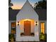 Home's front entrance showcasing a modern wood door, elegant sconces, and well manicured plants at 1183 Farm Quarter Rd, Mount Pleasant, SC 29464