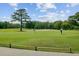 Scenic view of a golf course with players on the green, complete with sand traps and tree-lined fairways at 1183 Farm Quarter Rd, Mount Pleasant, SC 29464