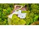 Aerial view of a modern farmhouse nestled among tall trees with a gravel driveway at 1183 Guerins Bridge Rd, Awendaw, SC 29429
