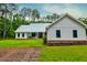 The farmhouse exterior view features a pristine lawn and mulched beds and covered porch at 1183 Guerins Bridge Rd, Awendaw, SC 29429