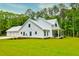 Expansive farmhouse with a metal roof, a three-car garage, and a large front yard at 1183 Guerins Bridge Rd, Awendaw, SC 29429