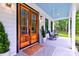 Welcoming front porch with a double wood door, rocking chairs and view of the yard, creating an inviting entrance at 1183 Guerins Bridge Rd, Awendaw, SC 29429