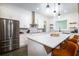 Well-lit kitchen with stainless steel appliances, white cabinets, and a large island with seating and quartz countertops at 1183 Guerins Bridge Rd, Awendaw, SC 29429