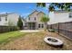 Spacious backyard featuring a fire pit, screen porch, lush lawn, and privacy fence at 121 Dream St, Summerville, SC 29483