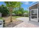Large backyard with a screened-in porch, lush lawn, mature trees, and a brick patio at 121 Dream St, Summerville, SC 29483