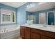 Stylish blue bathroom featuring a double sink vanity, bathtub, and glass-enclosed shower at 121 Dream St, Summerville, SC 29483