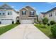 Two-story home with neutral siding, black shutters, and a two-car garage with a long driveway and well-maintained landscaping at 121 Dream St, Summerville, SC 29483