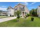 Corner view of a two-story house with a well-manicured lawn and a small tree in the front yard at 121 Dream St, Summerville, SC 29483