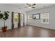 Living room with wood floors, a ceiling fan, three windows, a mirror, and a plant in the corner at 121 Dream St, Summerville, SC 29483