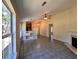 Open-concept living room with fireplace, tile flooring, ceiling fan, and an open kitchen with natural light at 124 Droos Way, Charleston, SC 29414