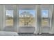 Bedroom view features three large windows offering great views, white curtains, and neutral carpet at 1481 Battery Reynolds Ct, Charleston, SC 29412