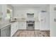 Bright kitchen features white cabinets, stainless steel appliances, granite counters, and wood-look floors at 1481 Battery Reynolds Ct, Charleston, SC 29412