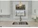 Close up on double bowl stainless steel kitchen sink with granite countertop and white subway tile backsplash at 1481 Battery Reynolds Ct, Charleston, SC 29412