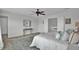 Neutral toned main bedroom with king bed, bedside tables, plush rug, ceiling fan, and hallway view at 1481 Battery Reynolds Ct, Charleston, SC 29412