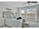 Main bedroom with king bed, bench, three large windows, ceiling fan, and plush rug at 1481 Battery Reynolds Ct, Charleston, SC 29412