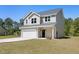 Two-story home with tan siding, a gray roof, an attached garage, and a well-maintained lawn on a clear day at 1518 Stanwick Dr, Johns Island, SC 29455