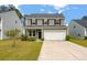 Charming two-story home with a well-manicured front yard and a two car garage at 153 Caleb Ct, Ladson, SC 29456