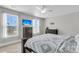 Bright and spacious bedroom with a modern ceiling fan, two windows, and a dark wood bedroom set at 1541 Homecoming Blvd, Ravenel, SC 29470