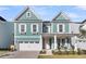 Charming two-story home featuring a front porch and a two-car garage at 1541 Homecoming Blvd, Ravenel, SC 29470