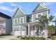 Attractive two-story home with a covered front porch, well-maintained landscaping, and a garage at 1541 Homecoming Blvd, Ravenel, SC 29470