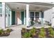 Cozy front porch with seating, complemented by fresh landscaping and a charming pink front door at 1541 Homecoming Blvd, Ravenel, SC 29470