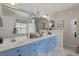 Bright bathroom with double sinks, quartz countertop, unique blue cabinetry and modern fixtures at 177 Sugar Magnolia Way, Charleston, SC 29414
