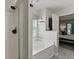 Bathroom featuring a glass shower, tub, and decorative shelving, leading to the adjacent bedroom at 177 Sugar Magnolia Way, Charleston, SC 29414