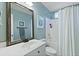 Inviting blue bathroom with a shower-tub combination, vintage mirror, and white sink vanity at 177 Sugar Magnolia Way, Charleston, SC 29414