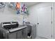 Modern laundry room featuring gray appliances and storage shelves at 177 Sugar Magnolia Way, Charleston, SC 29414
