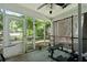 Enclosed screened-in porch featuring a workout bench and gym equipment at 177 Sugar Magnolia Way, Charleston, SC 29414