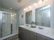 Well-lit bathroom featuring a double sink vanity, modern fixtures, and a glass-enclosed shower at 1865 Towne St, Johns Island, SC 29455