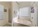 Bright bathroom featuring a garden tub, separate shower, and a window with privacy blinds at 1929 Treebark Dr, Charleston, SC 29414