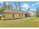 Back of the house with yellow siding, screened-in porch, and a fenced-in yard at 1953 Suzanne St, Johns Island, SC 29455