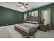 Bedroom with dark green accent wall, plush carpet, ceiling fan, and a comfortable gray bed at 1953 Suzanne St, Johns Island, SC 29455