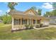 Beautiful exterior view of a home with a inviting front porch, shutters, and a well-kept lawn and landscaping at 1953 Suzanne St, Johns Island, SC 29455
