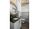 Chic powder room with a dark vanity, round mirror, and designer lighting fixture at 20 Old Cedar Ln, Kiawah Island, SC 29455