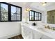 Bright bathroom with modern fixtures, double sinks, and a large window, for ample light and views at 20 Old Cedar Ln, Kiawah Island, SC 29455