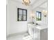 Bright bathroom featuring a modern chandelier, a double sink vanity, and a large mirror at 20 Old Cedar Ln, Kiawah Island, SC 29455