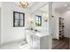 Bright bathroom featuring a modern chandelier, a double sink vanity, and a closet entrance at 20 Old Cedar Ln, Kiawah Island, SC 29455