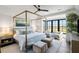 Bright primary bedroom featuring a four poster bed, sitting area, and beautiful views at 20 Old Cedar Ln, Kiawah Island, SC 29455