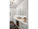 Stylish butler's pantry with white cabinets, marble countertop, and wine refrigerator at 20 Old Cedar Ln, Kiawah Island, SC 29455