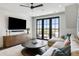 Bright living room featuring a large sectional sofa, media center, and doors to a deck with beautiful views at 20 Old Cedar Ln, Kiawah Island, SC 29455