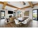 Open-concept living room and dining area with exposed wood beams and hardwood floors at 20 Old Cedar Ln, Kiawah Island, SC 29455