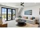 Bright living room featuring a large sectional sofa, contemporary art and doors to a deck with beautiful views at 20 Old Cedar Ln, Kiawah Island, SC 29455