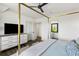 Bright main bedroom featuring a four-poster bed, ceiling fan, and an ensuite at 20 Old Cedar Ln, Kiawah Island, SC 29455