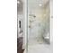 Bright, modern shower with marble tile, glass door, built-in bench, and sleek gold fixtures at 20 Old Cedar Ln, Kiawah Island, SC 29455