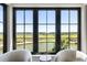 Stunning golf course view through large windows with seating, creating a serene ambiance at 20 Old Cedar Ln, Kiawah Island, SC 29455