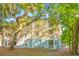 Low-angle exterior view of a three-story home featuring a screened-in porch and trees surrounding the building at 200 Bucksley Ln # 302, Charleston, SC 29492